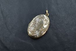 A 9ct gold locket of oval form having floral decorative engraving to the top, 4.5g Some small