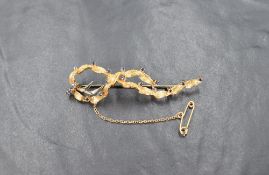 An 18ct gold and sapphire brooch in a flowing foliage motif, the gold leaves interspersed with