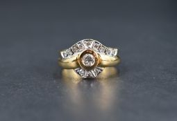 A diamond coronet style ring having a central collared diamond, approx 0.25ct within a curved border