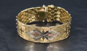 A 9ct three coloured gold articulated bracelet having patterned honeycomb links and concealed clasp,
