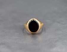 A 9ct gold signet ring having a black onyx oval panel, size O & approx 3.6g