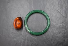 A vintage green glass bangle (with old repair) and a rough cut (polished) Baltic Amber pendant, no