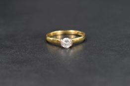 An 18ct gold diamond solitaire ring, the central round brilliant cut diamond measuring approximately
