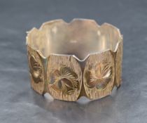 A vintage silver hinged bangle having panels with floral motif and textured engraving, marks for