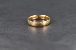 An 18ct gold wedding band, having decorative engraving to edges, ring size N, 4.4g