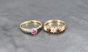 A ruby solitaire ring, the round cut ruby measuring approximately 0.20ct in a bezel setting with