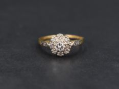 A diamond cluster ring, the central round brilliant cut diamond measuring approximately 0.20ct
