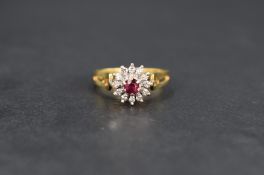 A ruby and diamond cluster ring, the central round cut ruby measuring approximately 0.20ct, with a