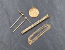 A small assortment of 9ct gold, comprising a tie pin having decorative engraving, a St Christopher