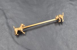 A yellow metal bar brooch stamped 15ct having moulded dog and cat terminals, approx 60mm long & 6.