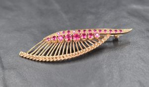 A 9ct gold ruby spray brooch, the linear set round cut rubies with gold spray motif and braided