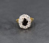 A sapphire and diamond cluster ring having a central oval sapphire within a surround of eight