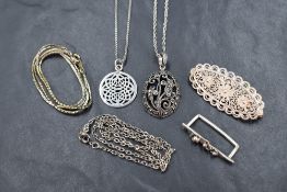 A collection of silver and white metal jewellery including a marcasite set floral motif pendant on a