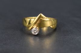 A yellow metal band ring stamped 18ct of stylised form having an inset collared diamond solitaire,