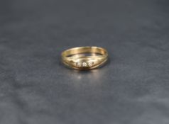 A yellow metal band ring stamped 9ct having three inset diamond chips in a moulded setting, size S &