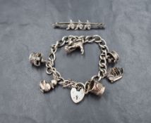 A silver charm bracelet having padlock clasp and six charms including kitten and duck, and a