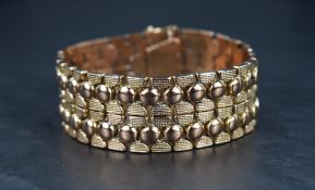 A rose gold articulated decorative link bracelet stamped 14K of broad form, having concealed