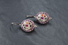 A pair of silver loop drop earrings, possibly Indian having a multi stone central panel within a