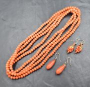 A long string of coral beads of small even form, approx 56' long with two pairs of coral drop