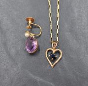 A blue sapphire pendant, the round cut sapphire set within an openwork heart, having a pierced heart