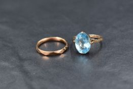 A 9ct rose gold wedding band having facet detail and another ring having blue paste oval gem stone
