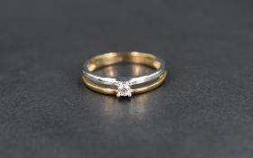A small diamond solitaire ring, approx 0.10ct in an open 9ct white and yellow gold split band,