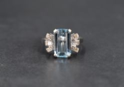 An Art Deco aquamarine and diamond ring, the central emerald cut aquamarine measuring