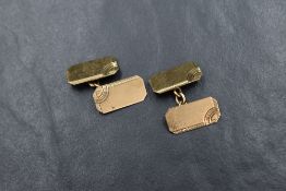 A pair of 9ct gold cufflinks, the rectangular panels having decorative engraving to the edges with
