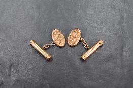 A pair of 9ct gold cufflinks having oval panels bearing floral engraving and chain connectors to