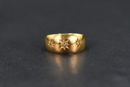 A small 18ct gold gypsy ring having three inset diamonds in star mounts, size J & approx 2.3g