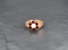 A garnet and opal cluster ring having a claw set raised mount on a 9ct gold bark effect loop, size L