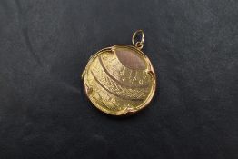 A yellow metal locket of circular form with engine turned decoration to top and reverse, marked '9ct