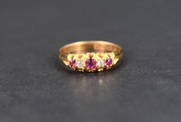 A ruby and diamond ring, the central ruby measuring approximately 0.08ct flanked by two diamonds and