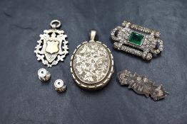 A small group of silver and white metal jewellery comprising a silver shield medal pendant, a silver