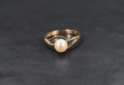 A cultured pearl solitaire ring, the pearl having a cream lustre with pierced and textured cross