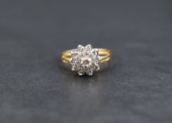 A diamond cluster ring, the central diamond measuring approximately 0.12ct having a step design with