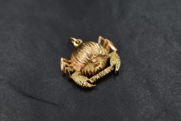 A yellow metal crab zodiac motif pendant or charm with 'cancer' between the claws, tests as high