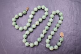 An Asian green hardstone bead necklace thought to be jade, the fifty uniform circular beads with a