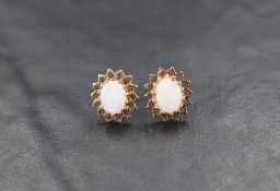 A pair of 9ct gold opal stud earrings, the opal cabochons set in a pierced halo setting, 2.2g