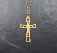 A 9ct gold cross pendant of pierced design having decorative sunburst engraving, on a yellow metal