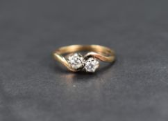 A diamond crossover ring, the two round cut diamonds set within crossover shoulders, on a 9ct gold