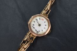 A 9ct gold cased wristwatch, the circular white dial with Arabic numerals within a geometric case on