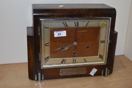 A 1930s oak cased mantel clock, of Art Deco design, having silvered Roman chapter ring, bearing