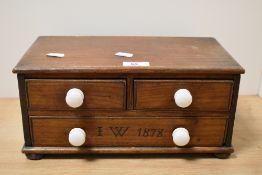 A late late 19th Century pine chest of two short and one long drawers, initialled and dated 1878