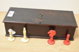 An early 20th Century stained oak box of bone and stained bone chess pieces, box dimensions 7cm x