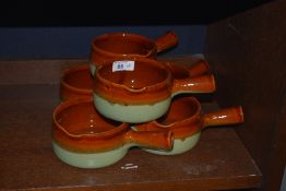 Six studio pottery soup dishes having brown and green glaze.
