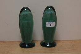 A pair of Victorian bottle green glass dump paperweights, of elongated form with internal