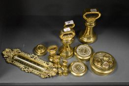An assorted collection of brassware, including bell weights and a thermometer