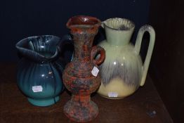 Three studio pottery jugs having decorative glazes.