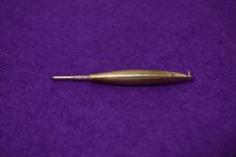 A small yellow metal propelling pencil with ring top. Engraved